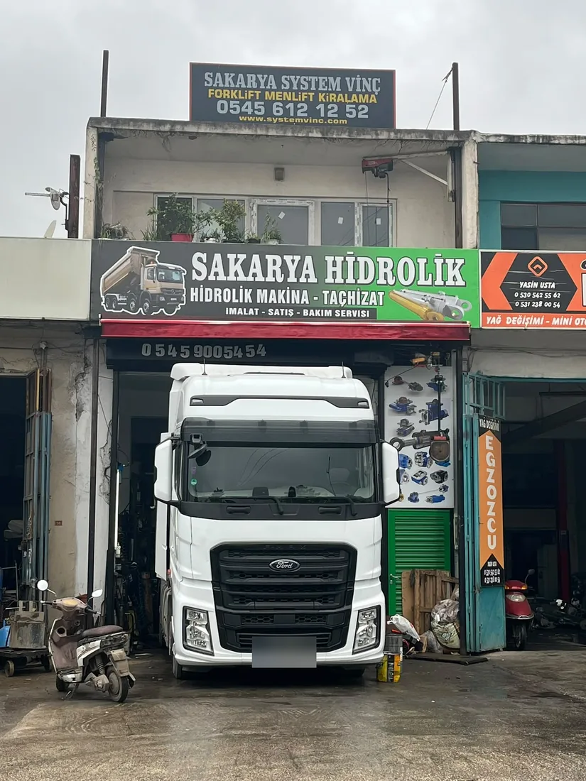 Sakarya Hidrolik servis girişi; önünde Ford kamyon, kapıda asılı hidrolik parça duvarı
